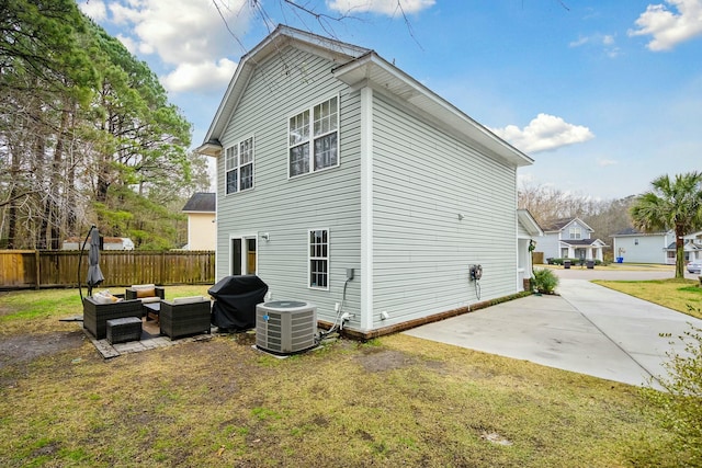 view of property exterior with a yard, an outdoor hangout area, central AC unit, a patio area, and fence