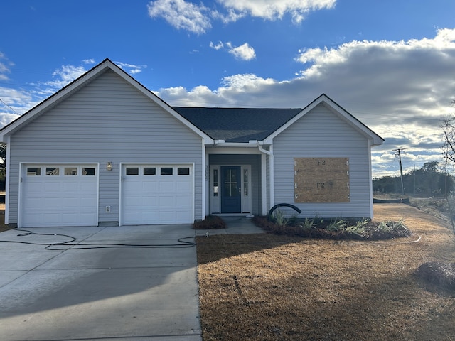 ranch-style house with concrete driveway, roof with shingles, and an attached garage