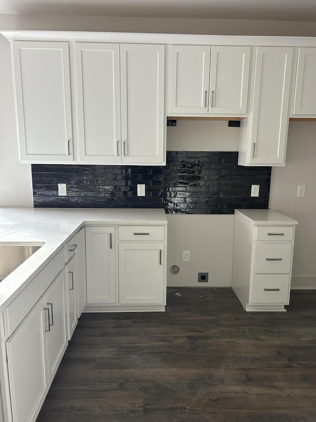 kitchen featuring light countertops, dark wood-style flooring, white cabinets, and backsplash