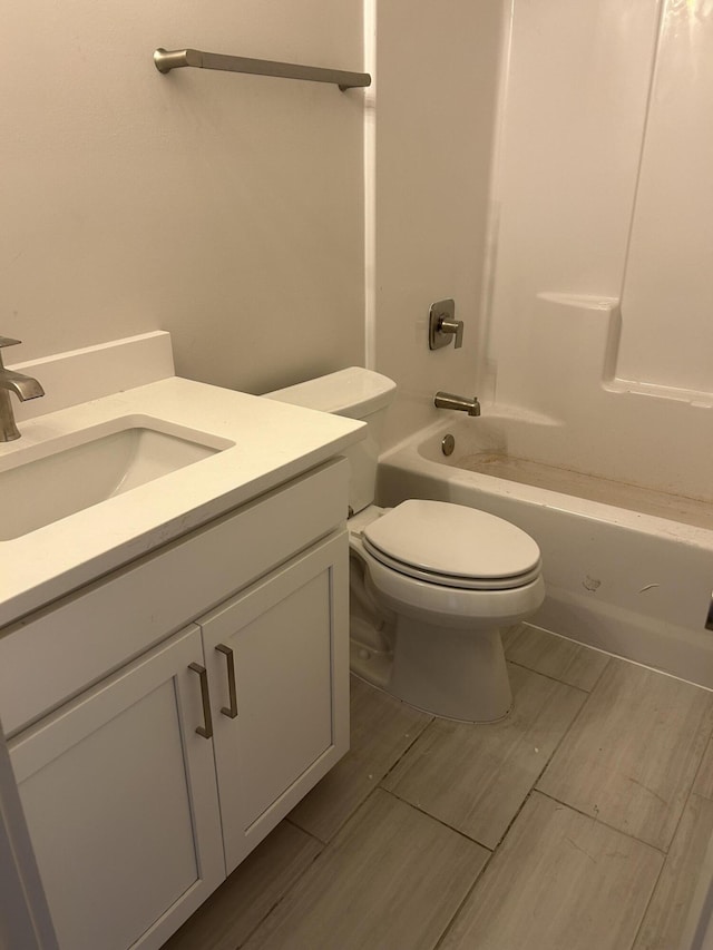 bathroom with tub / shower combination, vanity, and toilet