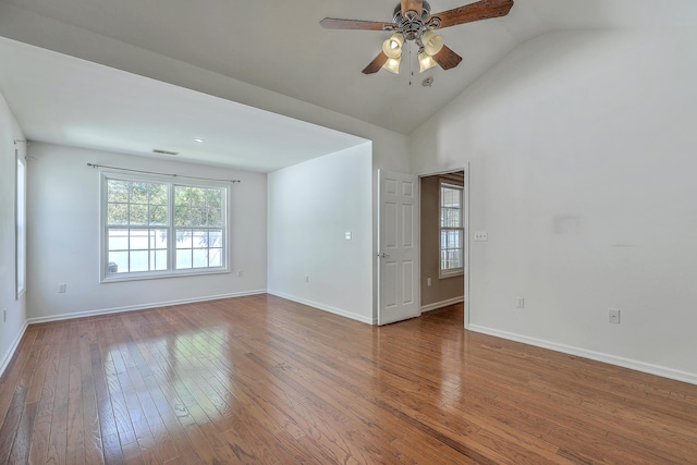 empty room with ceiling fan, visible vents, lofted ceiling, baseboards, and hardwood / wood-style flooring