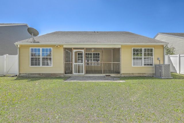 back of property featuring fence, a yard, central air condition unit, and a sunroom