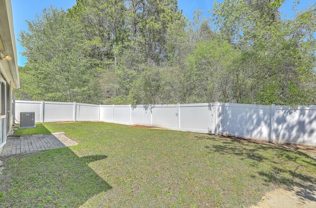view of yard with central AC, a fenced backyard, and a patio