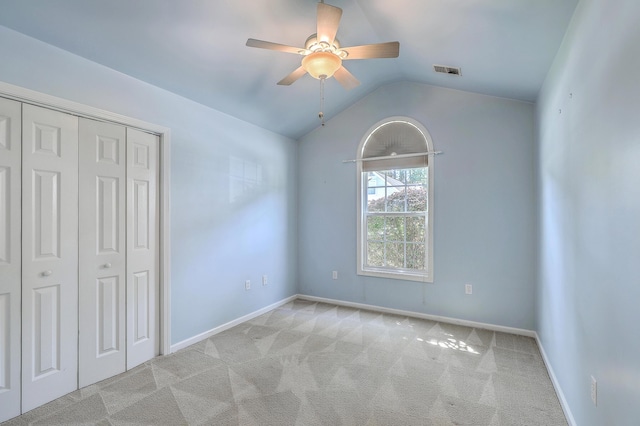 unfurnished bedroom with visible vents, carpet flooring, vaulted ceiling, and a closet