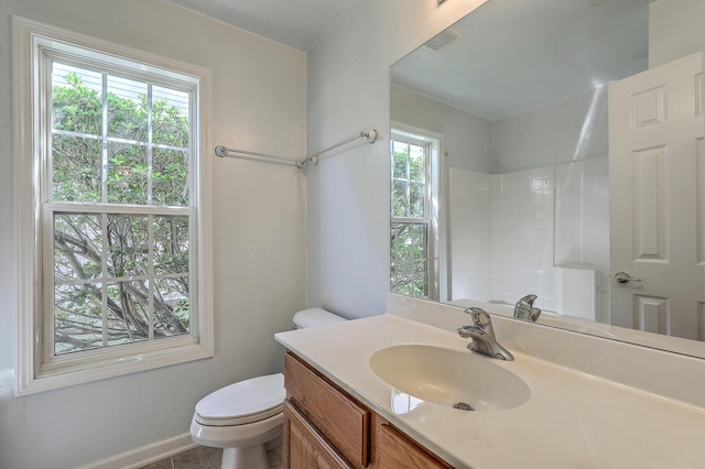 full bath featuring vanity, baseboards, walk in shower, toilet, and visible vents