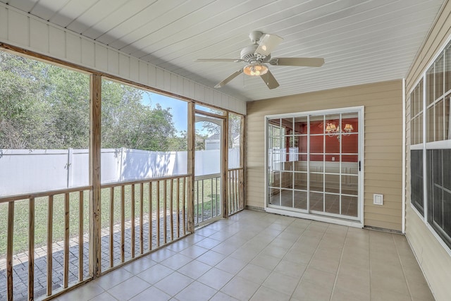unfurnished sunroom featuring a ceiling fan