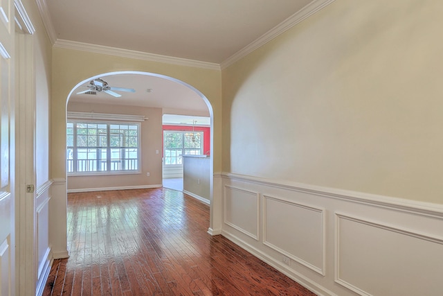 interior space with arched walkways, a wainscoted wall, hardwood / wood-style floors, and crown molding