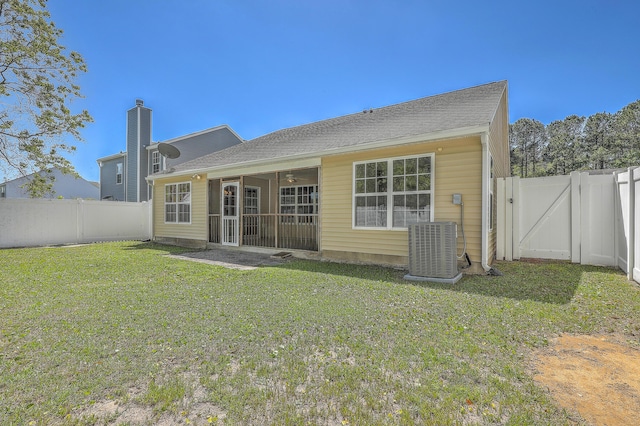 rear view of house with a fenced backyard, central AC, a gate, and a lawn