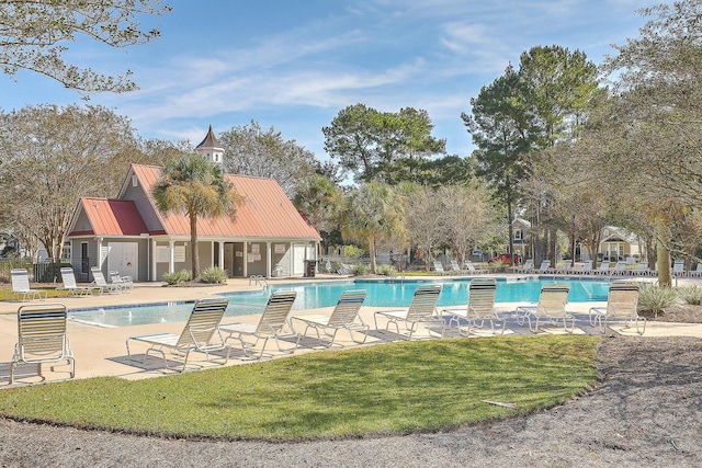 pool with a patio area, a yard, and fence