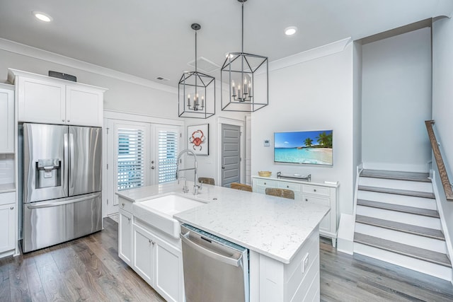 kitchen featuring sink, crown molding, a center island with sink, appliances with stainless steel finishes, and white cabinets