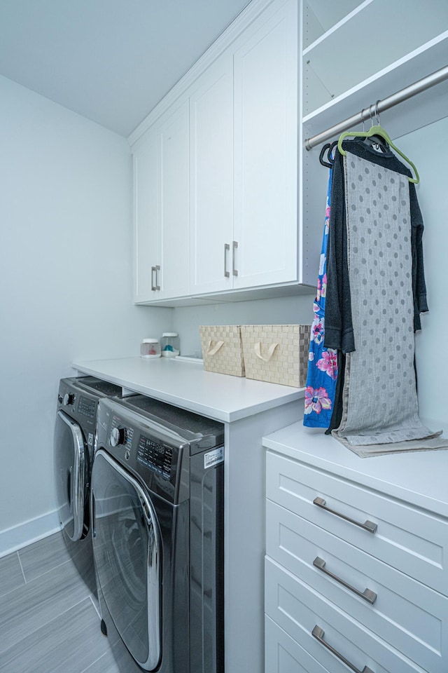 washroom with cabinets and washer and clothes dryer