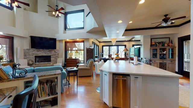 268 Little Oak Island Dr, Folly Beach, SC 29439 - kitchen featuring ceiling fan, a stone fireplace, light hardwood / wood-style flooring, and an island with sink