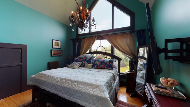 268 Little Oak Island Dr, Folly Beach, SC 29439 - bedroom with hardwood / wood-style flooring, vaulted ceiling, and an inviting chandelier