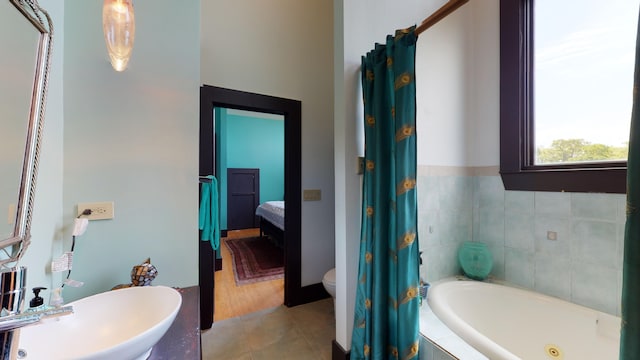 268 Little Oak Island Dr, Folly Beach, SC 29439 - bathroom with sink, a relaxing tiled tub, toilet, and hardwood / wood-style floors