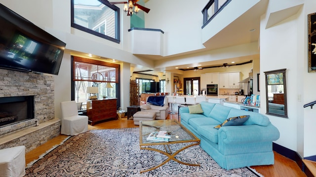 268 Little Oak Island Dr, Folly Beach, SC 29439 - living room with ceiling fan, a high ceiling, light hardwood / wood-style flooring, and a fireplace