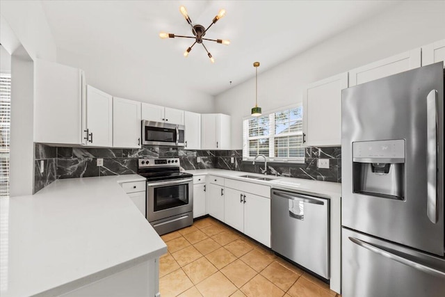 kitchen featuring light countertops, decorative backsplash, stainless steel appliances, white cabinetry, and a sink