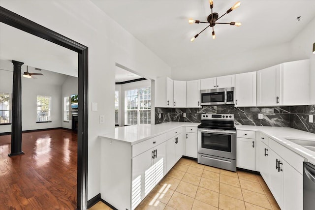 kitchen featuring decorative backsplash, plenty of natural light, stainless steel appliances, and vaulted ceiling