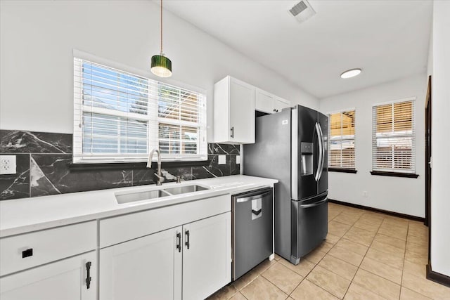 kitchen with visible vents, a sink, backsplash, white cabinetry, and stainless steel appliances