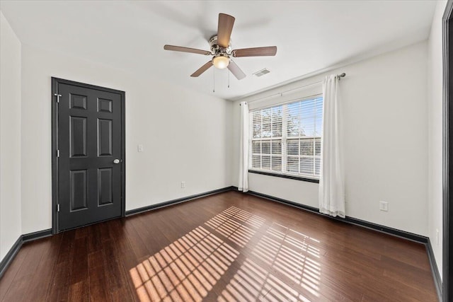 unfurnished room with visible vents, baseboards, wood finished floors, and a ceiling fan