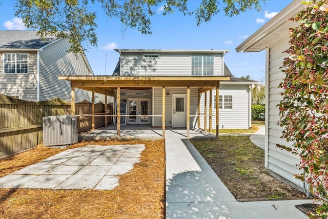 rear view of house featuring a patio, cooling unit, french doors, and fence