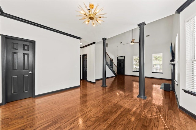 unfurnished living room featuring baseboards, wood finished floors, and crown molding