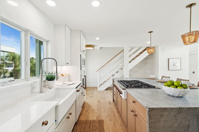 313 E Arctic Ave, Folly Beach, SC 29439 - kitchen featuring a sink, light wood-style flooring, stainless steel gas stovetop, recessed lighting, and light stone counters