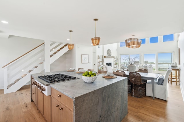 313 E Arctic Ave, Folly Beach, SC 29439 - kitchen featuring light wood-type flooring, stainless steel gas cooktop, decorative light fixtures, a kitchen island, and recessed lighting