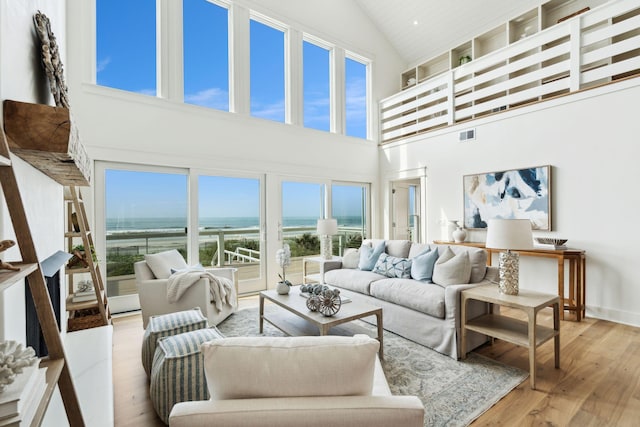 313 E Arctic Ave, Folly Beach, SC 29439 - living area with high vaulted ceiling, a water view, and wood finished floors