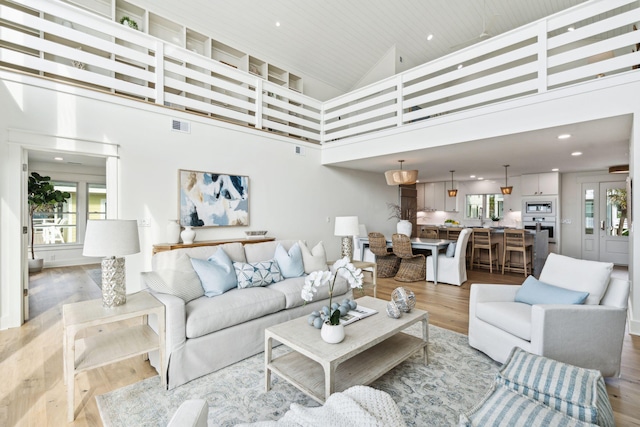 313 E Arctic Ave, Folly Beach, SC 29439 - living room featuring light wood-style floors, high vaulted ceiling, and recessed lighting