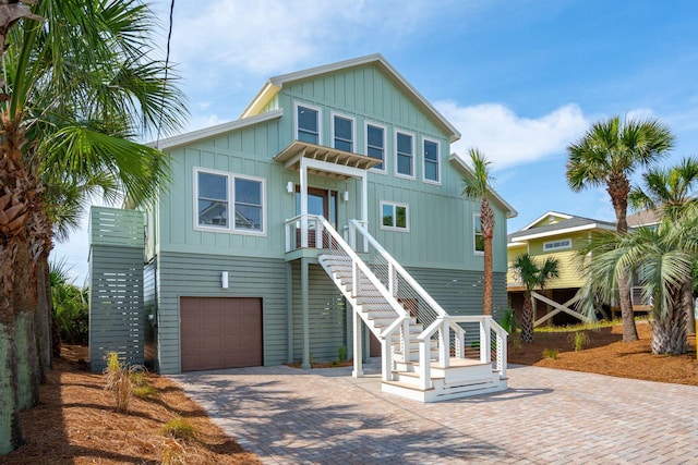 313 E Arctic Ave, Folly Beach, SC 29439 - raised beach house with board and batten siding, decorative driveway, a garage, and stairs