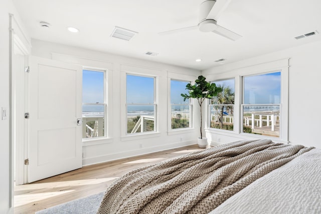 313 E Arctic Ave, Folly Beach, SC 29439 - unfurnished bedroom with wood finished floors, multiple windows, recessed lighting, ceiling fan, and a water view