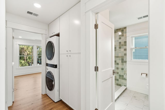 313 E Arctic Ave, Folly Beach, SC 29439 - laundry room featuring stacked washer and clothes dryer, cabinet space, and recessed lighting