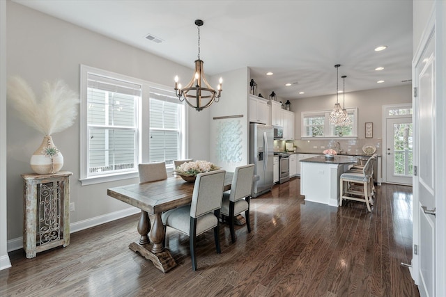 dining room with a barn door, baseboards, dark wood-type flooring, a notable chandelier, and recessed lighting