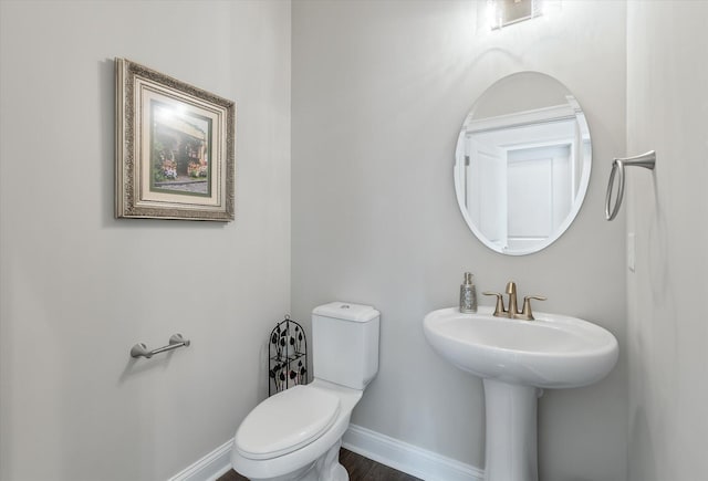 bathroom with toilet and baseboards