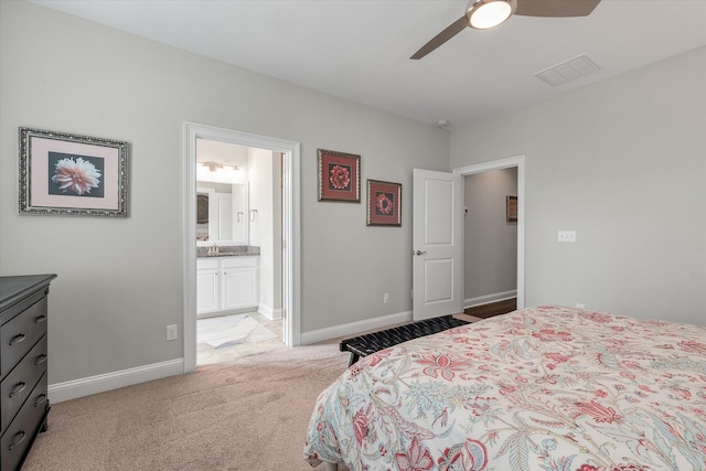 bedroom with visible vents, ensuite bathroom, light carpet, ceiling fan, and baseboards