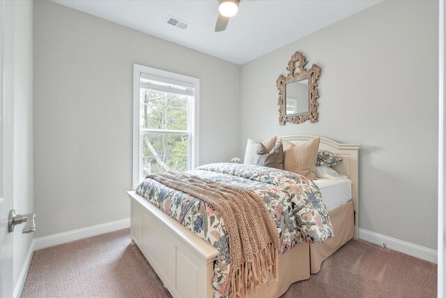 bedroom with light carpet, ceiling fan, visible vents, and baseboards