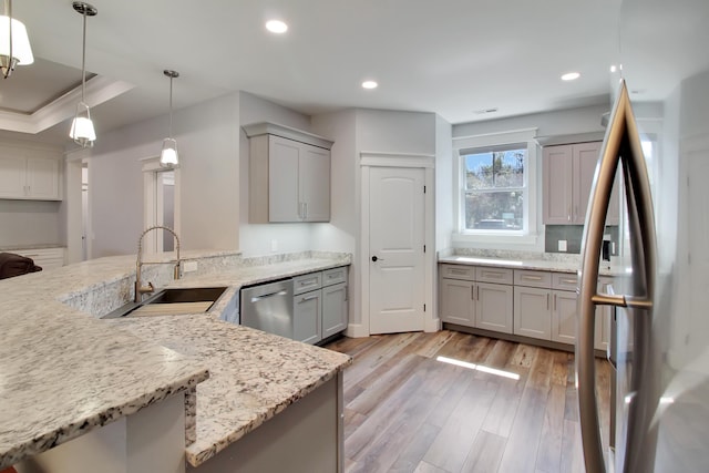 kitchen with a sink, dishwasher, gray cabinetry, and light wood finished floors