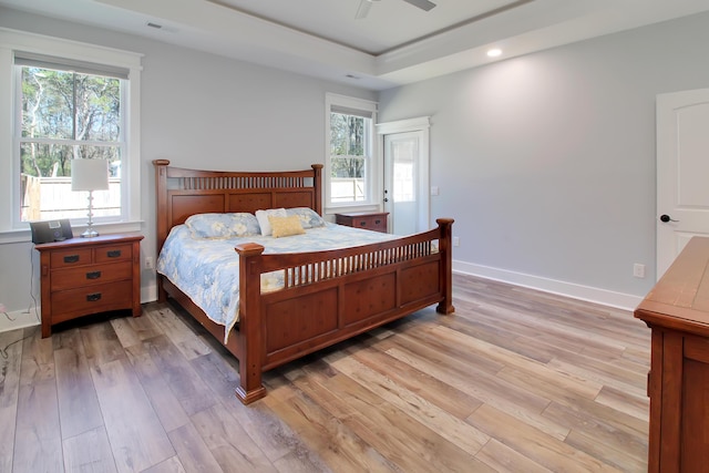 bedroom featuring light wood-type flooring, visible vents, and multiple windows