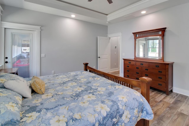 bedroom featuring a ceiling fan, baseboards, a tray ceiling, recessed lighting, and light wood-style floors