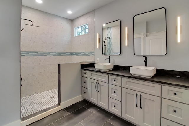 full bathroom featuring double vanity, tile patterned flooring, walk in shower, and a sink