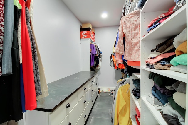 walk in closet featuring dark tile patterned flooring