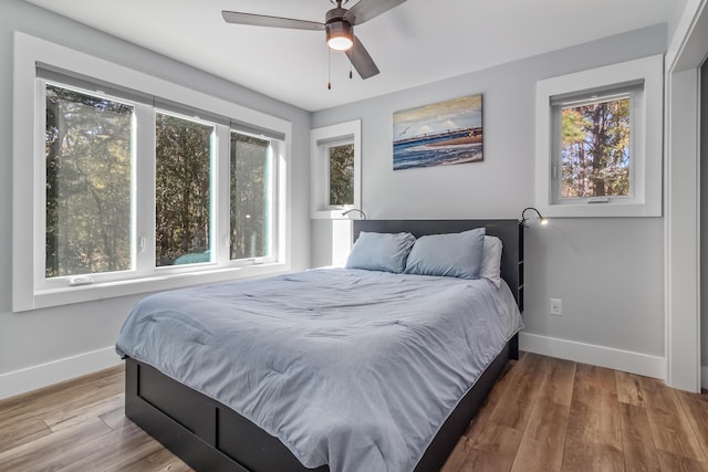 bedroom featuring a ceiling fan, wood finished floors, and baseboards