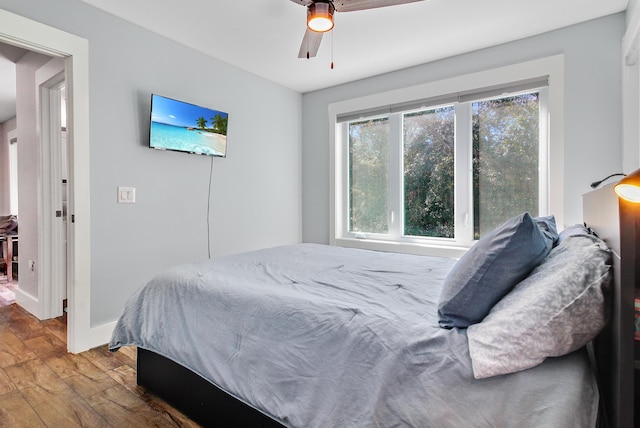 bedroom featuring wood finished floors, baseboards, and ceiling fan