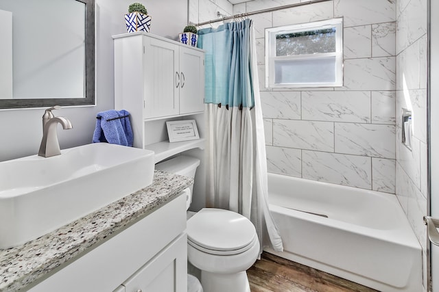 bathroom featuring vanity, toilet, wood finished floors, and shower / bath combo with shower curtain