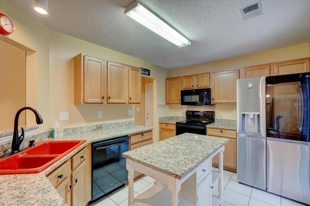 kitchen featuring black appliances, sink, light tile patterned floors, and a textured ceiling