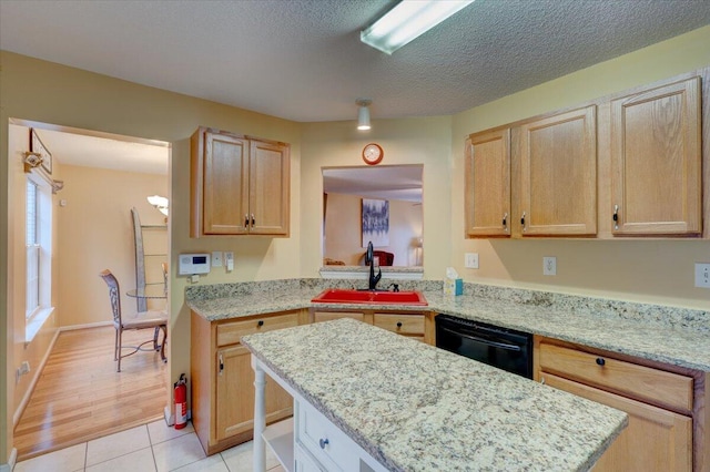 kitchen with light hardwood / wood-style floors, light brown cabinetry, sink, and black dishwasher