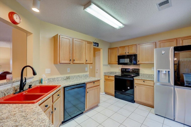 kitchen with light brown cabinets, a textured ceiling, black appliances, and sink