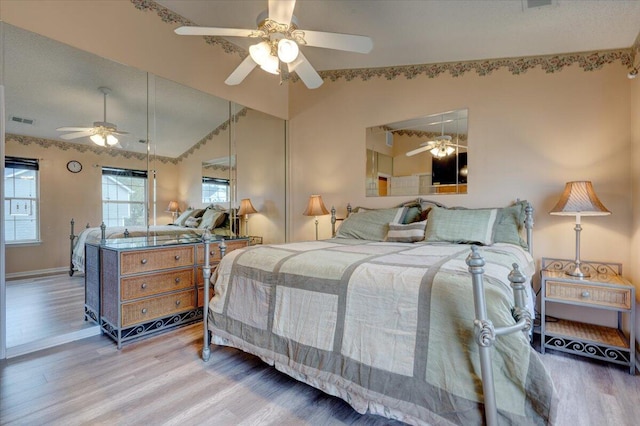 bedroom with hardwood / wood-style floors, vaulted ceiling, and ceiling fan