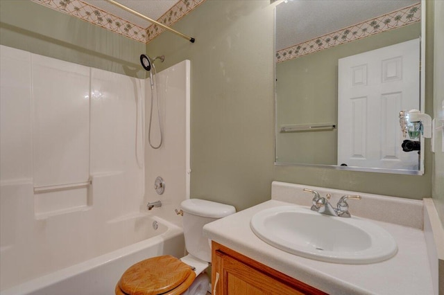 full bathroom featuring toilet, vanity, a textured ceiling, and shower / washtub combination