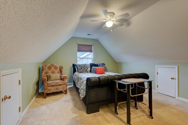 bedroom with a textured ceiling, light colored carpet, ceiling fan, and vaulted ceiling